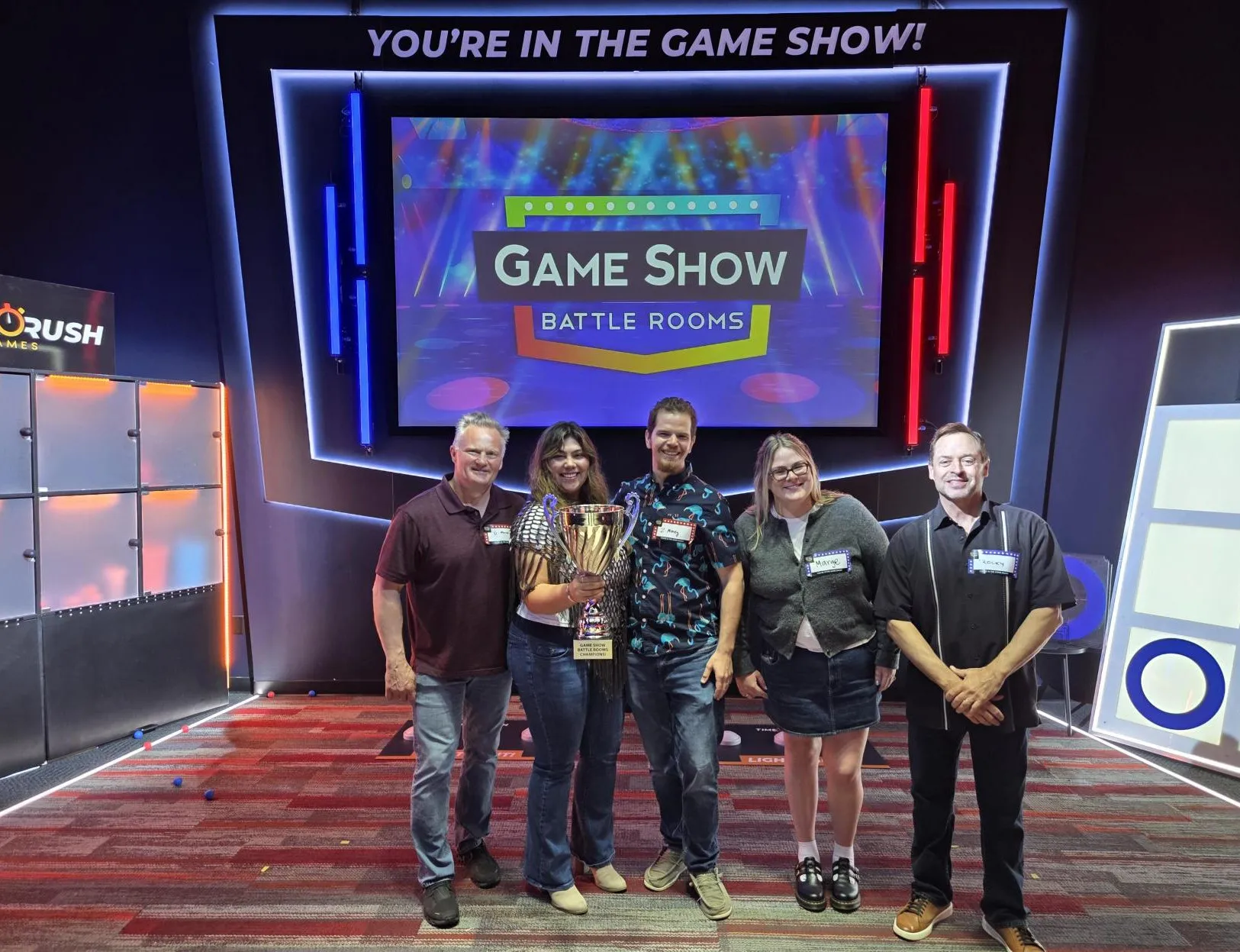 The team holding a trophy at a game show night
